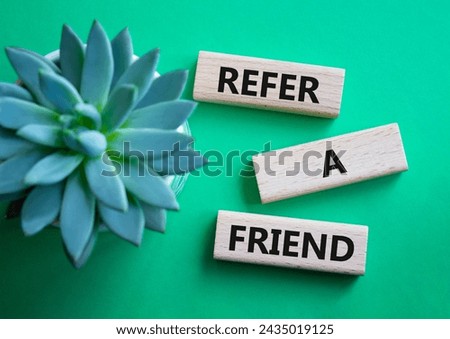 Refer a Friend symbol. Concept words Refer a Friend on wooden blocks. Beautiful green background with succulent plant. Business and Refer a Friend concept. Copy space.