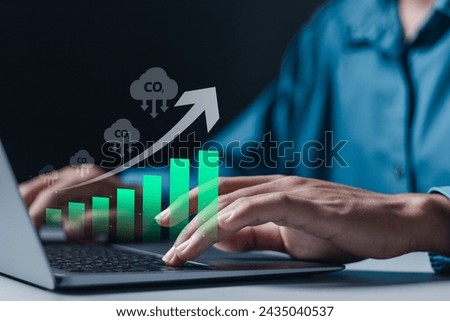 Businessman use laptop with growth graph of CO2 reducing. Climate change to limit global warming and sustainable development and green business concept.