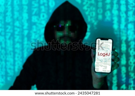 Cybersecurity vulnerability Log4J and hacker,coding,malware concept. Hooded computer hacker in cybersecurity vulnerability Log4J on server room background.