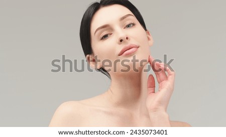 Portrait of a young woman isolated on a light background. Skin care. Beautiful female model with perfectly clean fresh skin. Natural beauty and cosmetology concept