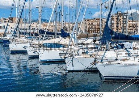 boats and yachts on pier in marine city port with masts and bulidings and blue sky on background , water cityscape of urban port Royalty-Free Stock Photo #2435078927