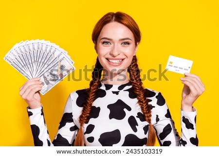 Photo of funky cheerful woman wear cow skin print top comparing cash credit card isolated yellow color background