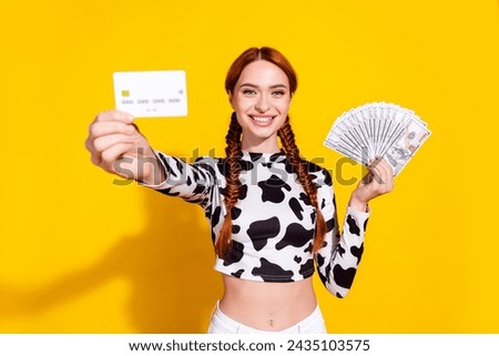 Photo of cheerful excited woman wear cow skin print top choosing credit card instead cash isolated yellow color background