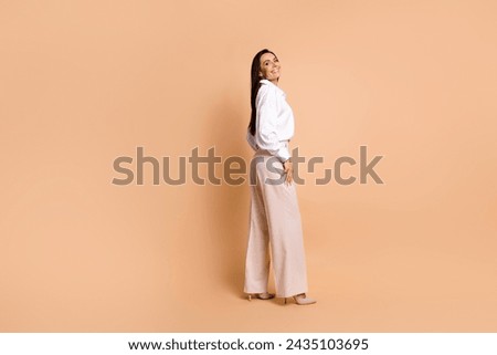Full body profile photo of stunning positive lady posing classy clothes empty space isolated on beige color background