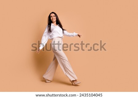 Full length photo of shiny sweet lady dressed white shirt walking high heels shoes empty space isolated beige color background