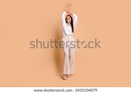 Full size photo of peaceful lovely elegant girl raise hands empty space ad isolated on beige color background