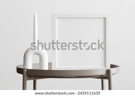 White square frame mockup with a candle decoration on the beige table.