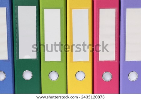 Bright binder office folders as background, closeup Royalty-Free Stock Photo #2435120873