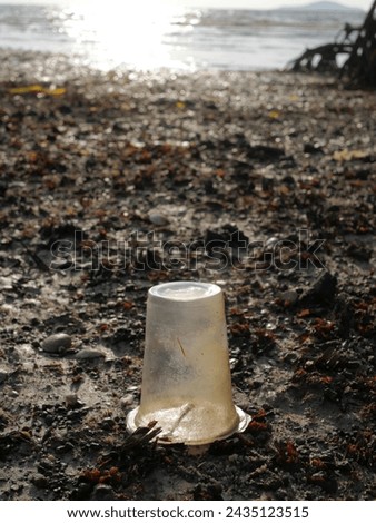 Empty plastic glass on the beach, concept of keeping the environment clean, no trash on the beach

 Royalty-Free Stock Photo #2435123515