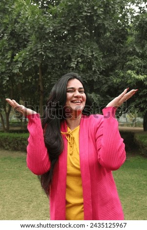 Portraits of Cheerful, Carefree, Beautiful  indian woman enjoying and spending quality at park. woman gesturing different expressions by using hands at park vacations.