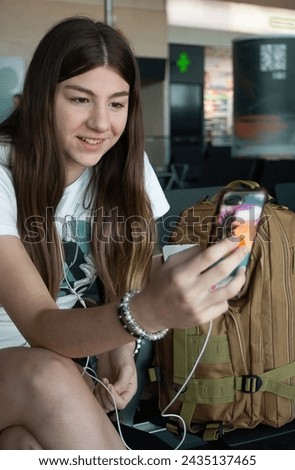 Teenager in airport terminal chatting on mobile phone