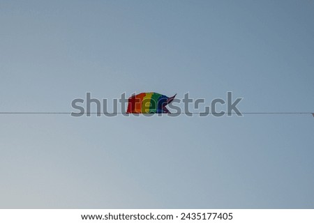 Small horizontal lgbt flag on blue sky background