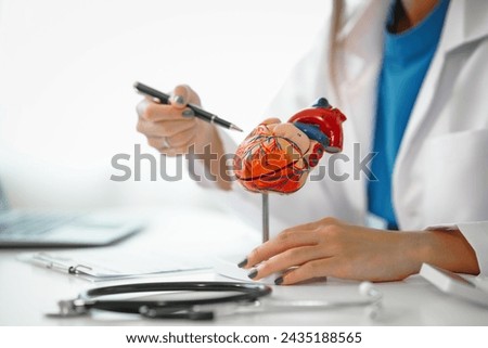 Female doctor provides crucial guidance to a male patient in a clinic room, discussing heart attack prevention, prescribing medication, and emphasizing well-being at the appointment desk.