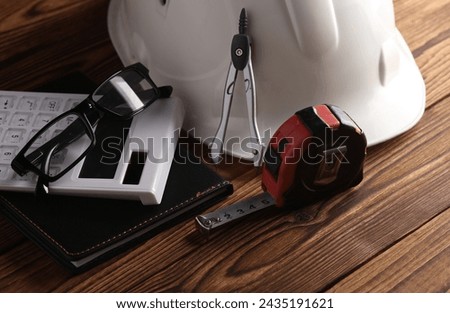 Engineer's tools and white blank business card on wooden boards.
