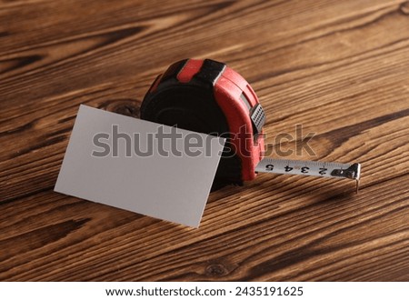 Construction ruler and business card on wooden boards