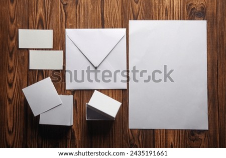 Mockup of white blank sheets of paper, notepad, business cards, envelope, box  on wooden boards. Template for design. Business concept. Flat lay