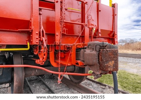 Close-up image of the end of a restored red vintage train, railroad, caboose including coupling.  Royalty-Free Stock Photo #2435195155