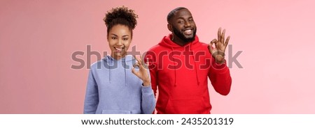 Two african-american skilful coworkers professionals assured friend everything perfect smiling broadly delighted nodding agree approval gesture show okay ok not bad choice sign, pink background. Royalty-Free Stock Photo #2435201319