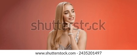 Feminine elegant wealthy woman attend luxurious party look tender left touching cheek wearing expensive trendy brilliant accessorize silver glittering dress, standing red background confident. Royalty-Free Stock Photo #2435201497