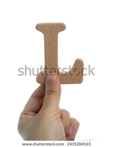 Hand holding wooden letter L