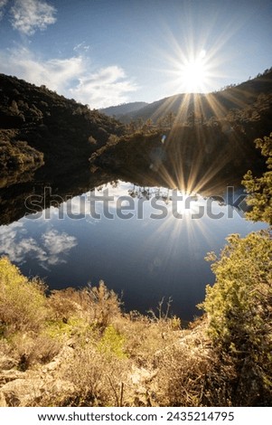 Vanadal lake taken against the light whit the sun in the blue sky. In la Garde(Freinet, in the south of France, in Massif des Maures, in Europe. Lake of oaks and stone.  Royalty-Free Stock Photo #2435214795