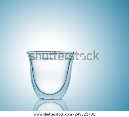 Glass with carbonated water on blue gradient background, high depth of field, studio shot
