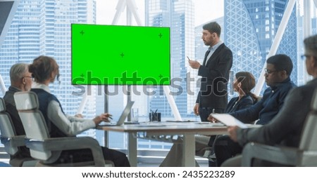 Office Conference Room Meeting Presentation: Caucasian Businessman Talks, Uses Green Screen Chroma Key TV Set. Male CEO Successfully Presenting a e-Commerce Product to Group of Multi-Ethnic Investors.
