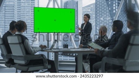 Office Conference Room Presentation: Beautiful Businesswoman Talks, Uses Green Screen Chromakey TV. Entrepreneur Presents e-Commerce Product On Meeting With Diverse Investors. Dramatic Evening Edit.