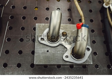 Welded production of external wastegate manifold from stainless steel, exhaust manifolds in a turbocharged car. Royalty-Free Stock Photo #2435235641