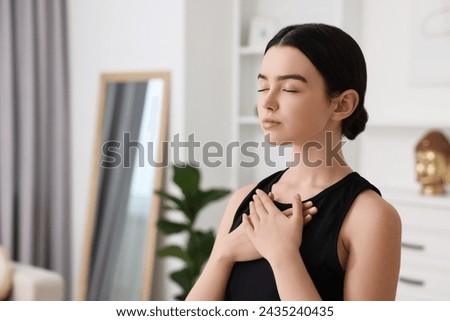 Beautiful girl meditating at home. Practicing yoga