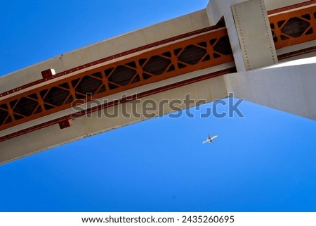photo of the April 25 bridge in Lisbon over the Tajo River.
Portugal suspension bridge on blue sky. photo taken from the bottom of the bridge. Flying plane on a blue background

