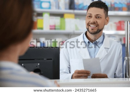 Professional pharmacist working with customer in drugstore