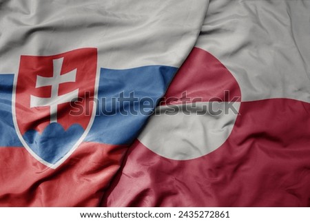 big waving national colorful flag of greenland and national flag of slovakia . macro