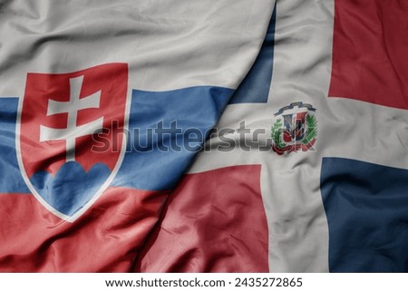 big waving national colorful flag of dominican republic and national flag of slovakia . macro