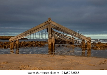 Wooden structure on the beach with natural water reflection 