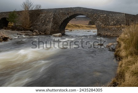 Slow shutter release silky water river under arched bridge