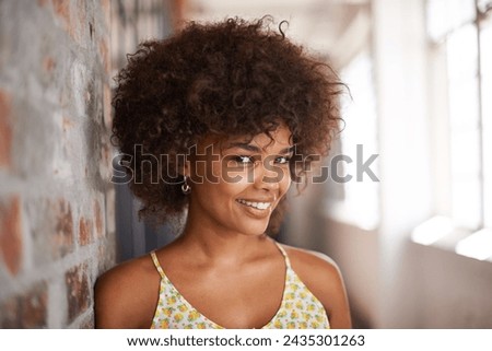 Portrait, happy and woman by brick wall at university for education, learning or confidence in corridor alone. Face, student and young girl in hallway of college for profile picture in South Africa
