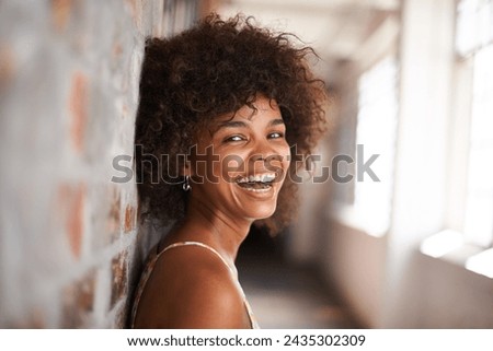 Portrait, smile and woman by brick wall at college for education, learning or funny laugh in corridor alone. Face, student and happy girl in hallway of university for profile picture in South Africa