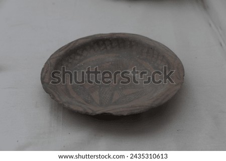 A terracotta bowl featuring intricate geometric patterns from the Mohenjo-Daro site, representing the artistic expression of the Indus Valley Civilization, photographed for clarity and detail