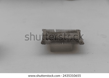Displayed is a terracotta comb from Mohenjo-Daro, reflecting personal grooming habits of the Indus Valley Civilization, photographed on a plain background to emphasize detail Royalty-Free Stock Photo #2435310655