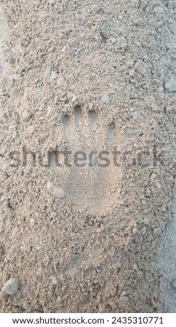 A beautiful picture of a hand print on sand at beach 