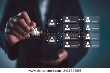 Organization chart, mind map. Businessman uses a pen to draw an organigram on a virtual screen. HR Manager works on HR company structure tree diagram, resource leveling, and career path concepts. Royalty-Free Stock Photo #2435324555