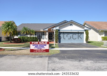 Real estate for sale open house welcome sign Suburban back split style home residential neighborhood clear blue sky USA