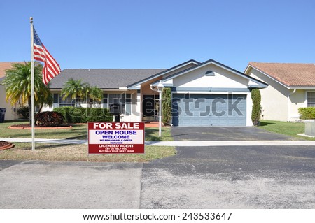 American flag pole real estate for sale open house welcome sign Suburban back split style home residential neighborhood clear blue sky USA