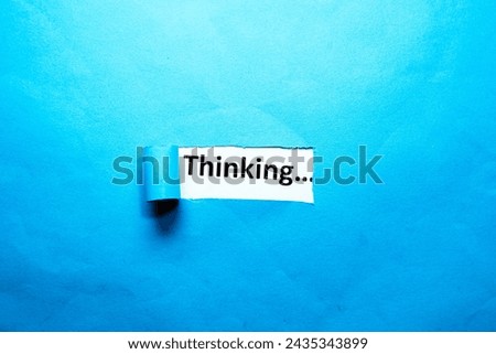 Thinking text written on torn paper blue background copy space