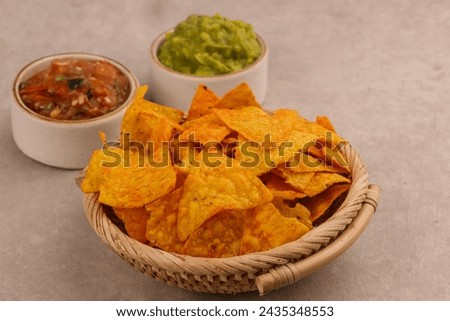 Tortilla Chips or Nachos with Two Super Bowl Dips which are Salsa and Guacamole.