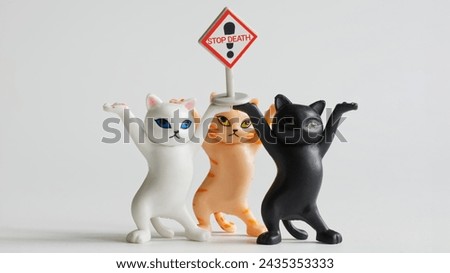 Three toy kittens went on a demonstration with a stop death placard. White background.  Toy world. Photo. Close-up