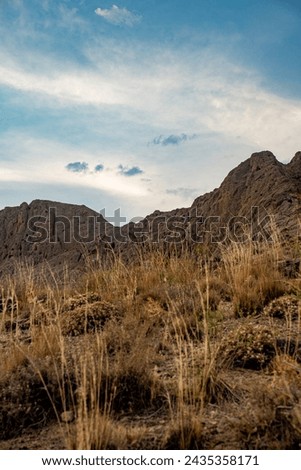 beautiful blue sky at desert with cloudy shapes, moor and rocks at sunset