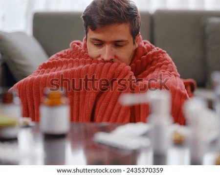 autumn and winter season of sneezes. Young Caucasian Sick man with fever lying on couch at home. Idea of cold, flu, virus or allergy.