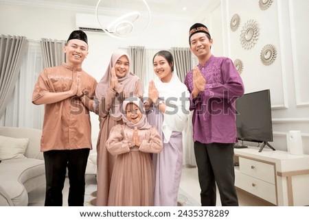 Portrait of two Muslim families forgiving each other when Idul Fitri or Eid al-Fitr. Eid Mubarak concept Royalty-Free Stock Photo #2435378289